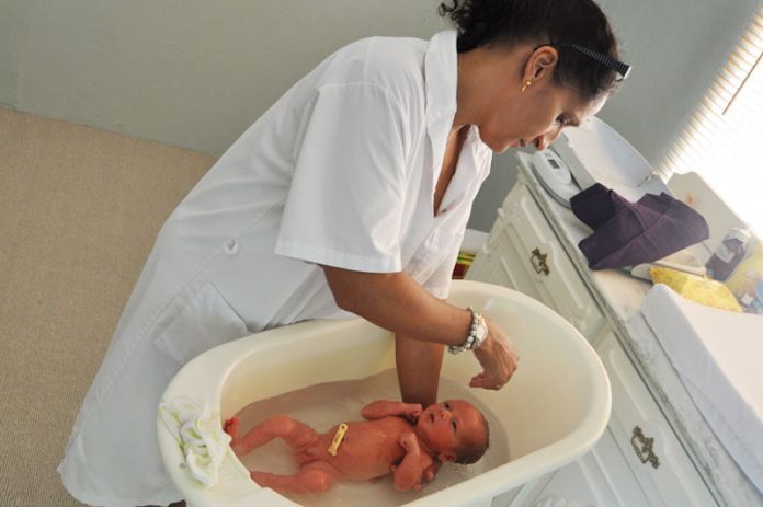 Kraamzorg nuttig en effecties Kraamverpleegkundige wast baby