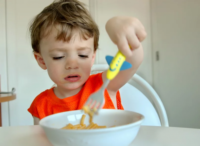 eetprobleem jongetje worstelt met bord spaghetti