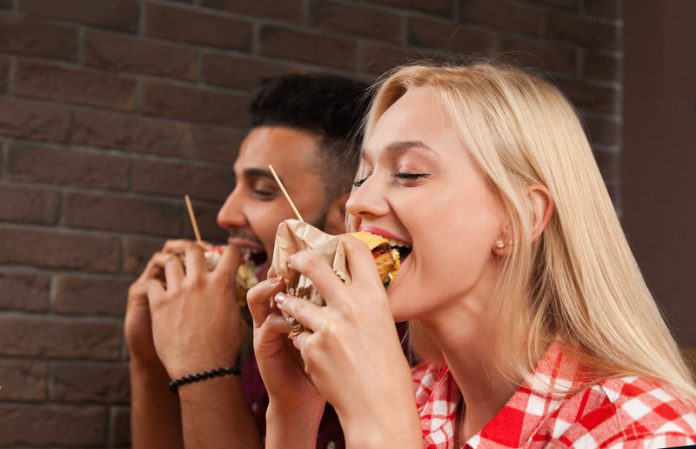 Fast food cs voruw en man eten burgers