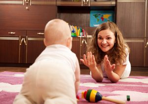 moeder speelt met baby op de grond